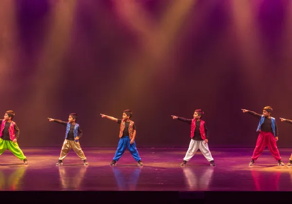 Boys Bollywood Dance team performing a synchronized routine on stage at Spotlight Academy, Spring & The Woodlands TX
