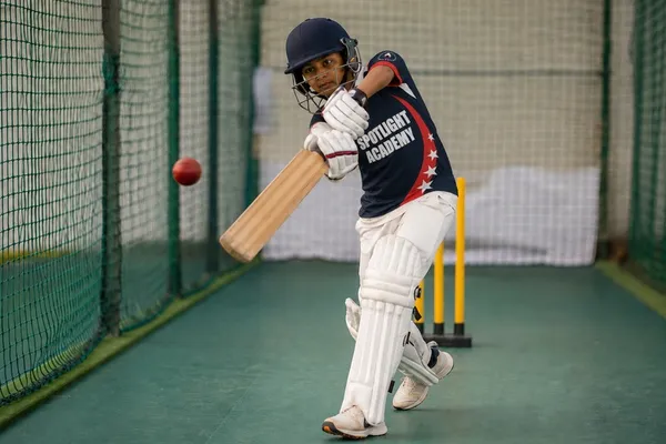 Spotlight Academy cricket student playing a drive shot in indoor batting nets, The Woodlands TX