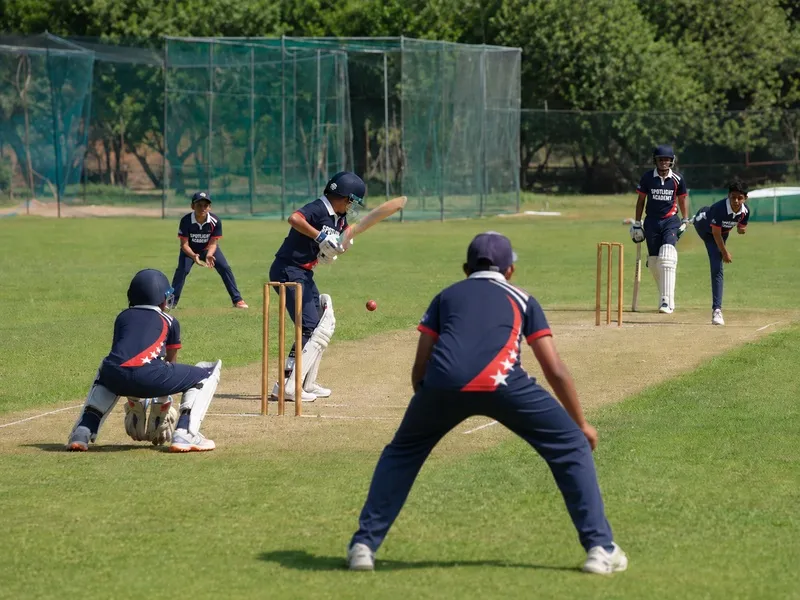 Cricket students playing a full outdoor match with batter, wicket keeper and fielders, Spotlight Academy in Spring & The Woodlands TX